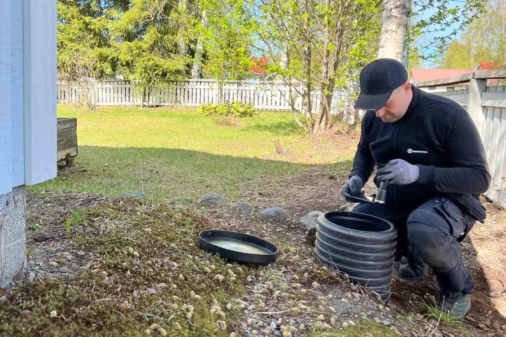 Kuntotarkastaja tutkii salaojien tarkastuskaivoa.