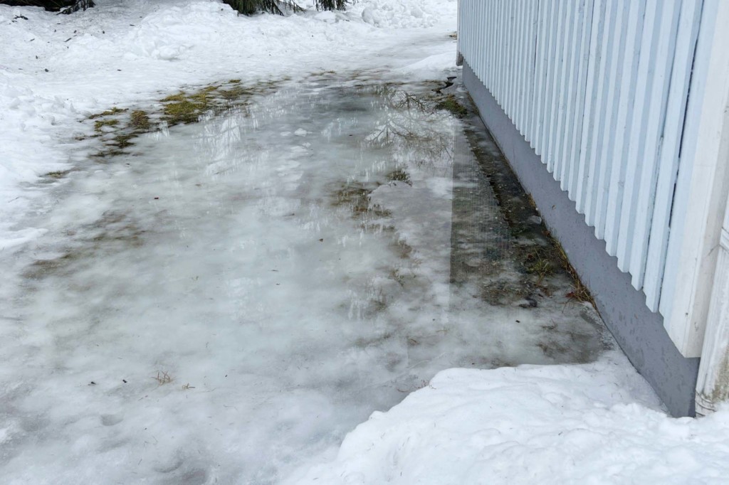 Sokkelin vieressä lainehtii vettä, kun katolta tuleva sulamisvesi on ohjautunut väärin